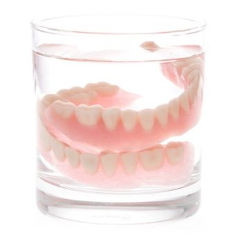 dentures soaking in a glass