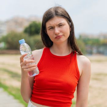 woman with bottled water that may contain microplastics